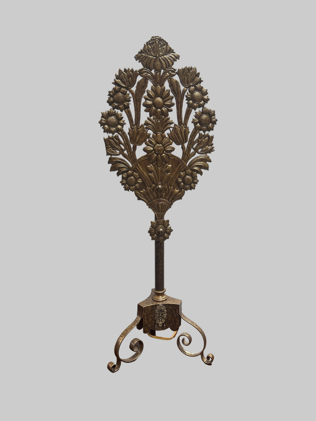 Decorative metal stand with floral design on a gray background