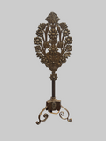 Decorative metal stand with floral design on a gray background