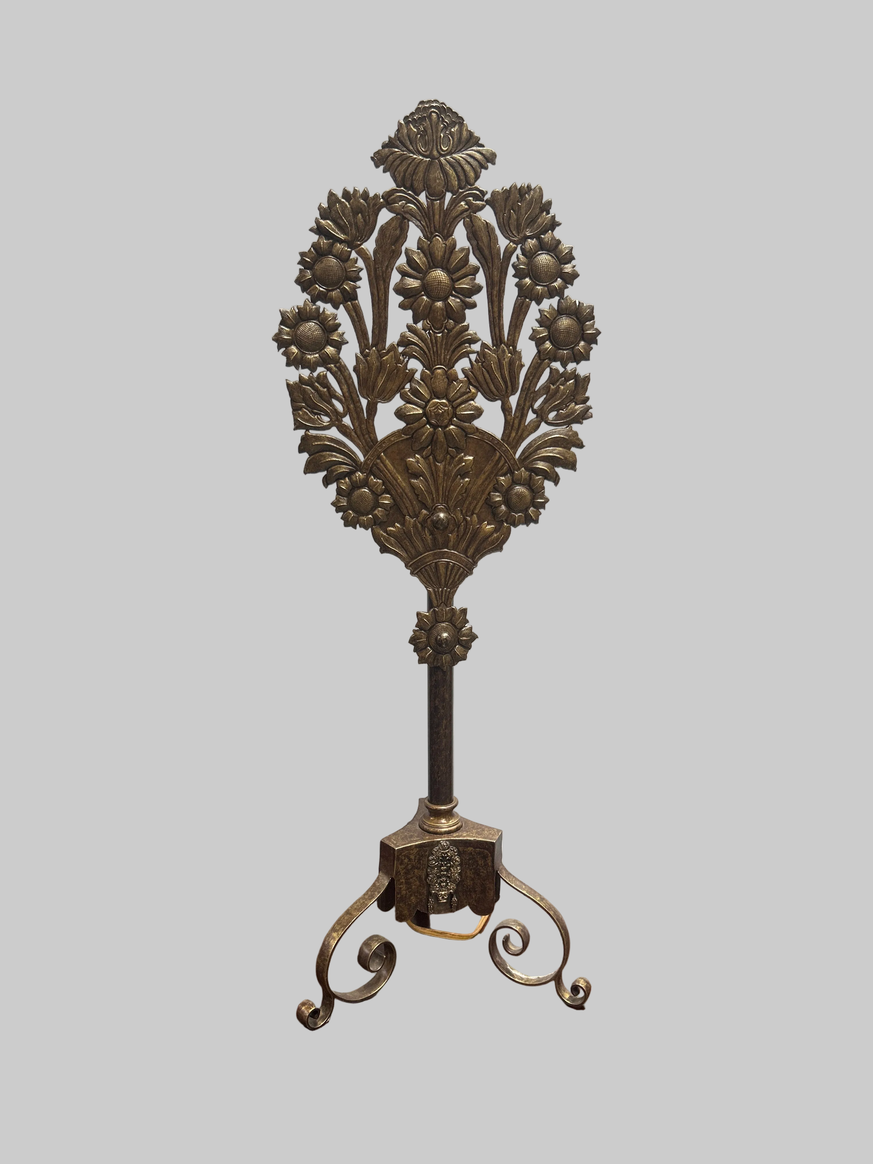 Decorative metal stand with floral design on a gray background